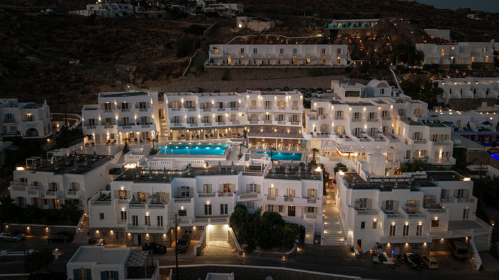 The George Hotel Mykonos φωτισμένο το βράδυ με τις πισίνες του.