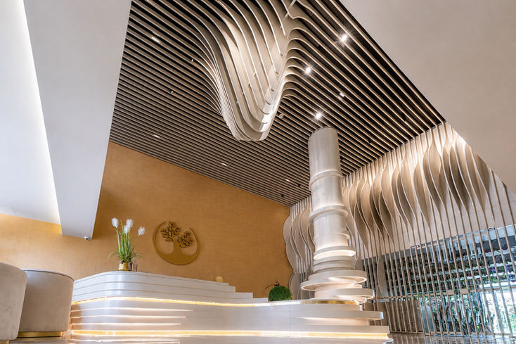 Μοντέρνα ρεσεψιόν του Green Suite Hotel με εντυπωσιακή οροφή.