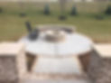 Circular patio built and designed in metro ATL along with a circular fire pit, seating wall and stone pillars leading to it