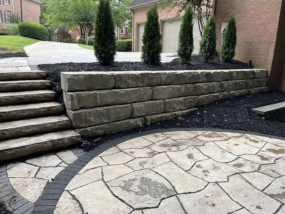 Natural stone slab steps beside a terraced retaining wall and flagstone patio in Alpharetta, GA