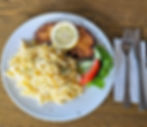 Ein leckeres Schnitzel mit Pommes und Beilagensalat wie auf der Speisekarte beschrieben