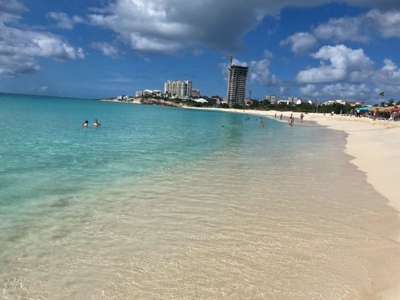 Beautiful beach in Sint Maarten featuring calm turquoise water, soft white sand, and scenic coastal views near luxury beachfront resorts.