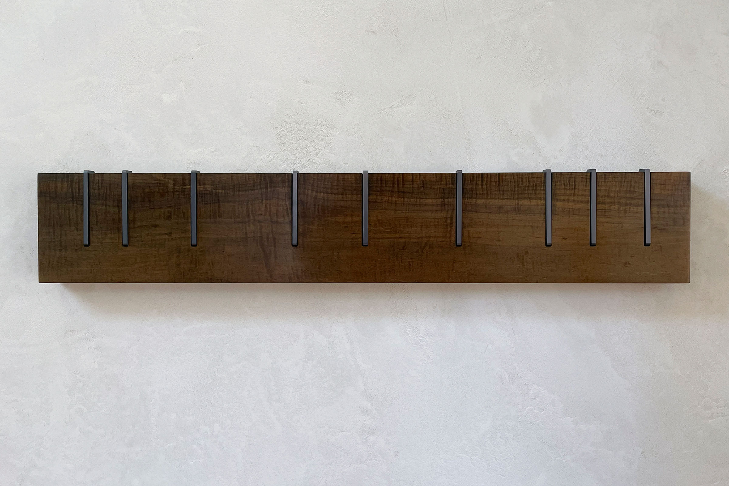 Symbol X Maple No. 12 - main view of wood coat rack on plaster wall