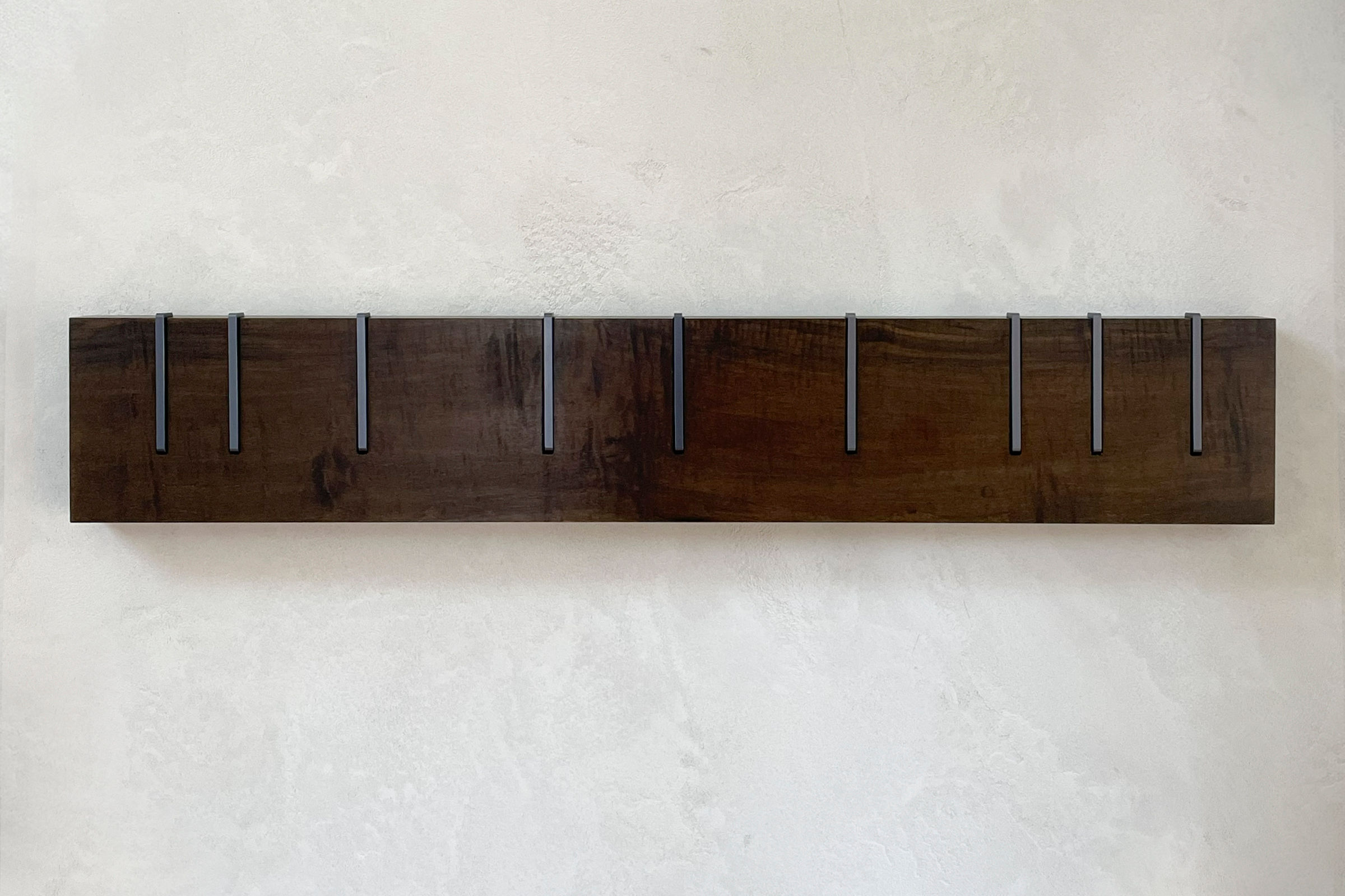Symbol X Maple - No. 10 - straight on view of the wood coat rack on a plaster wall