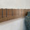 Thumbnail: Symbol X Maple - No. 13 - angled view of wood coat rack on plaster wall with jean jacket hanging from one hook
