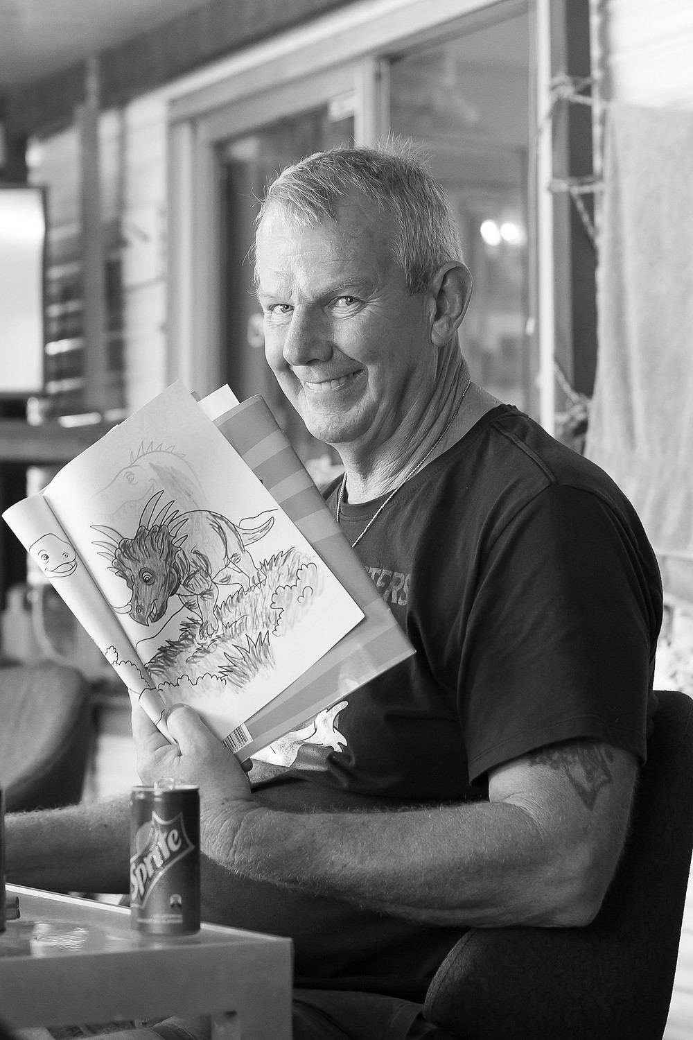 Man holding colouring in book smiling