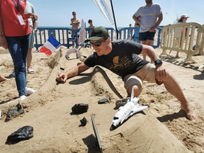 Un homme lance sa bille sur le circuit en sable