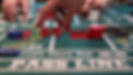 Craps table with hand reaching for dice to roll with chips on the table.jpeg