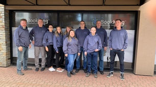 Lineup of Book King team in matching Univerus sweatshirts in front of Book King office.