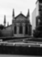 Black and white view of a gothic church with tall spires next to a modern car park ramp at St Enoch, Glasgow, by david gulliver photography