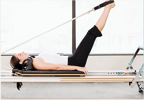 girl on Pilates reformer with feet in straps