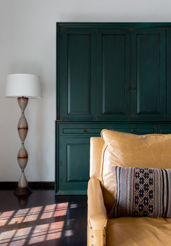 Living Room with Green Painted Cabinet, Floor Lamp and Swivel Leather Chair