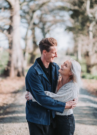 Couple looking at each other and embracing under canopy of trees in Raglan during a photoshoot