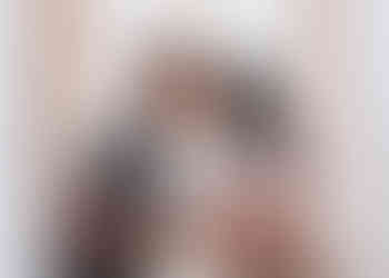 Couple kissing while holding their newborn during their family photos