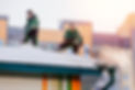 Snow cleaning. Team male workers roof of