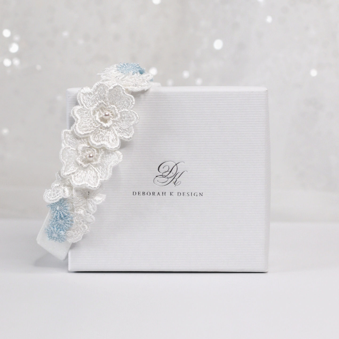 Bridal garter with ivory and blue lace flowers, finished with crystals and pearls