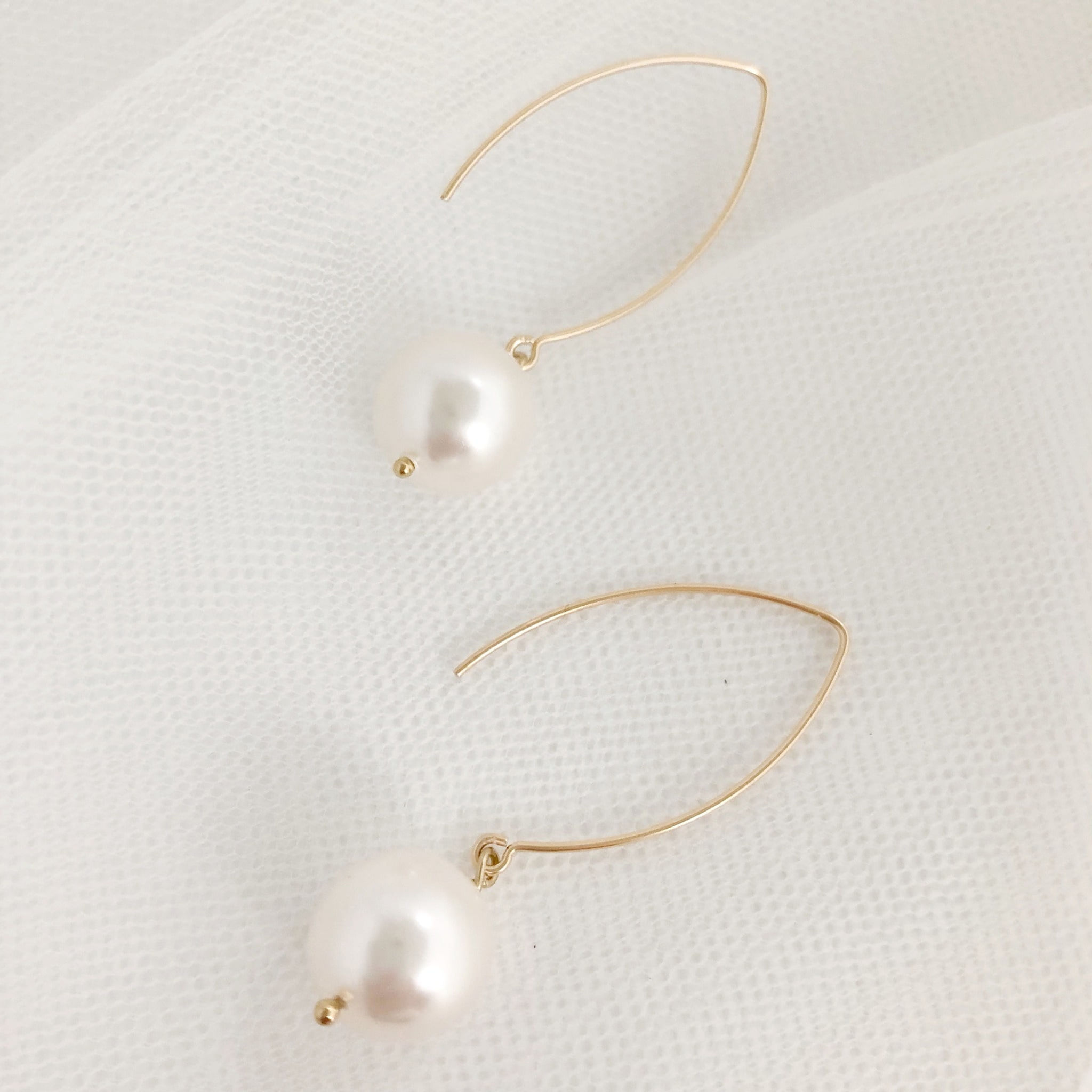 Gold hook over earrings with an ivory pearl dropper
