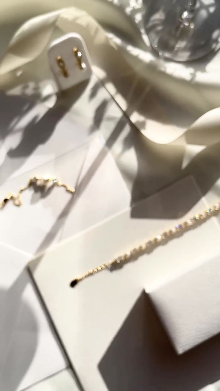 Thumbnail: Gold bracelet with a delicate cubic zirconia solitaire on either side of an ivory freshwater pearl. With extender chain.