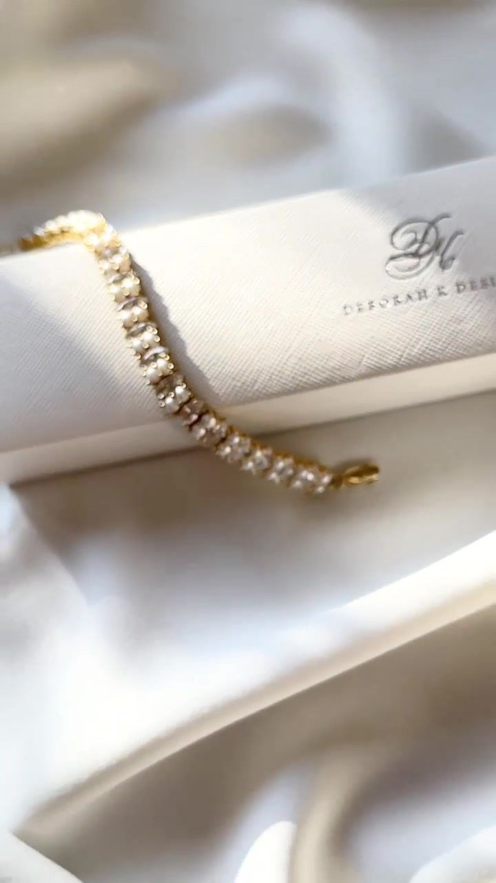 Thumbnail: Gold marquise cut cubic zirconia and ivory pearl bridal tennis bracelet.