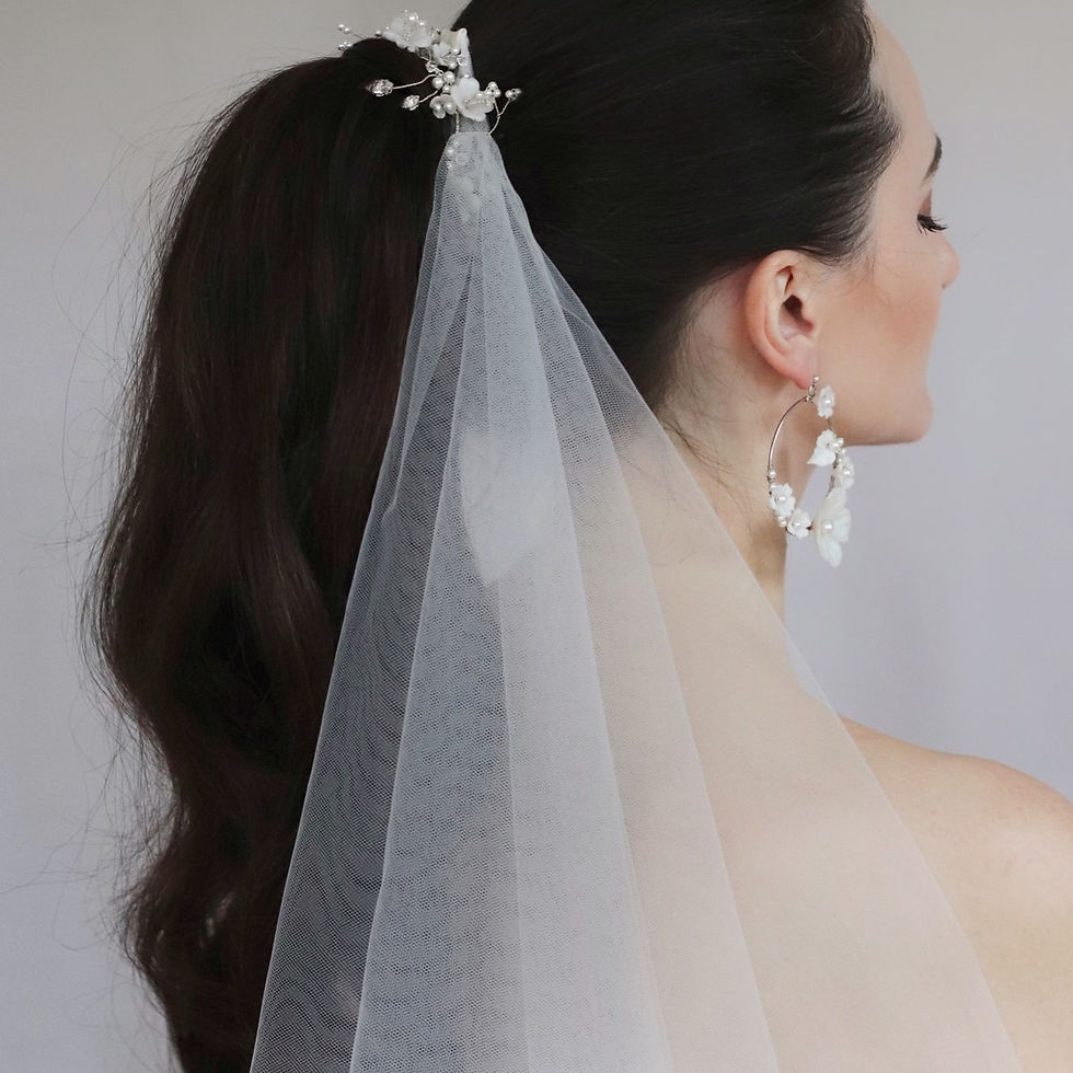 Thumbnail: Ivory tulle ponytail veil modelled by bride