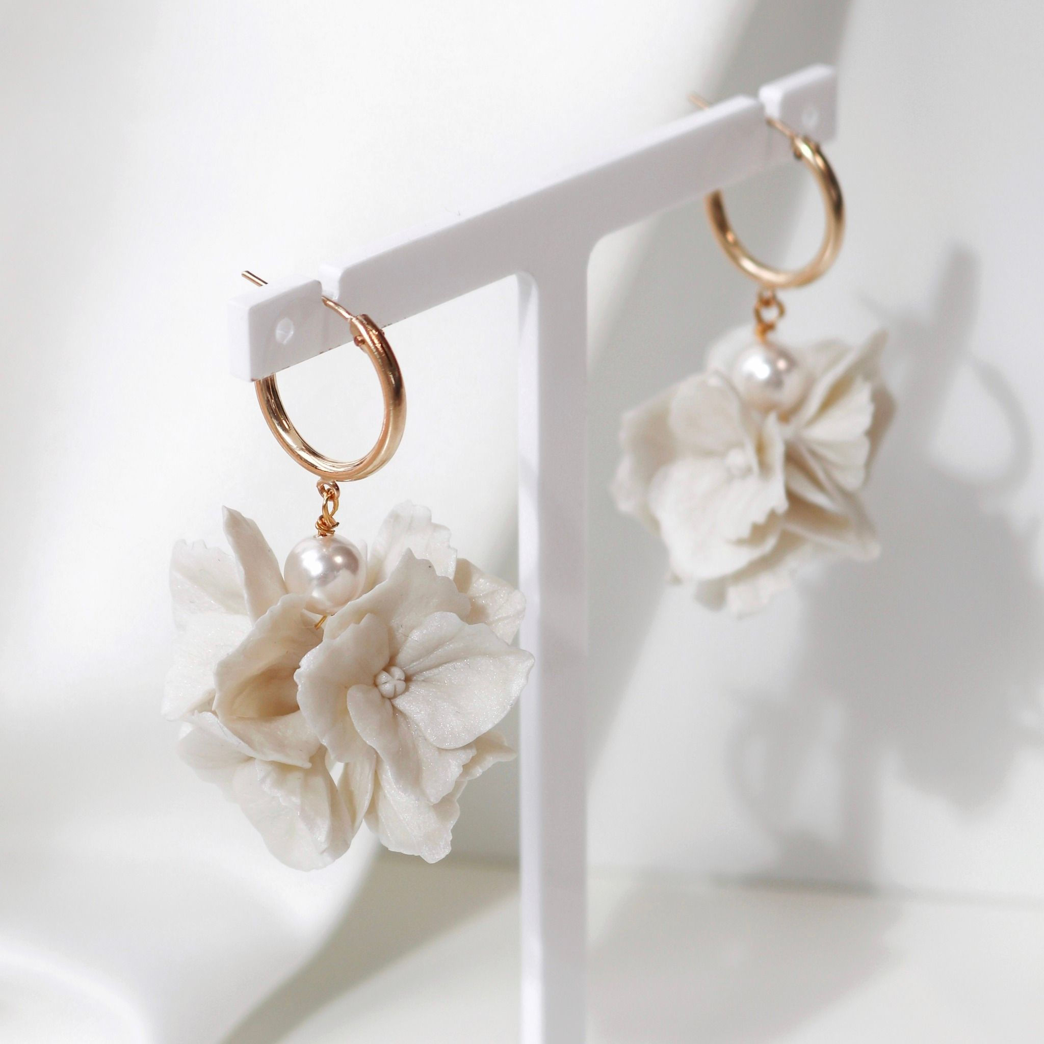 Gold hoop earrings with ivory clay flower cluster and ivory pearls.