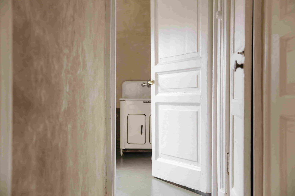 Puerta entreabierta hacia una habitación que está a punto de ser pintada.