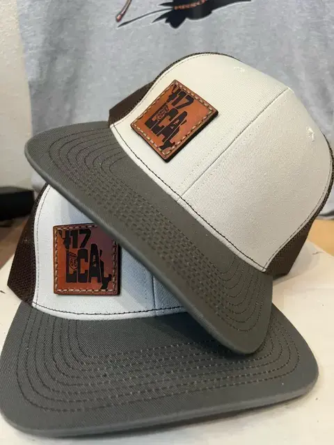 Thumbnail: White front panel and gray bill trucker hat with brown mesh backing, featuring a leather "417 Local" Route 66 patch, stacked