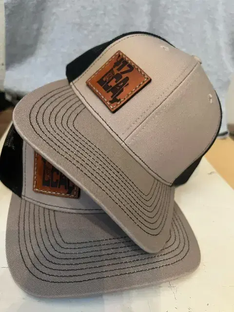 Thumbnail: Close-up of tan and black trucker hat with brown leather '417 Local' patch, highlighting the Route 66 emblem and detailed sti