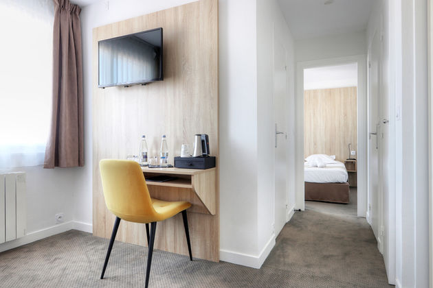 Espace bureau de la Chambre Familiale Côté Cour de l’Hôtel La Petite Sirène à Quiberon avec télévision et chaise