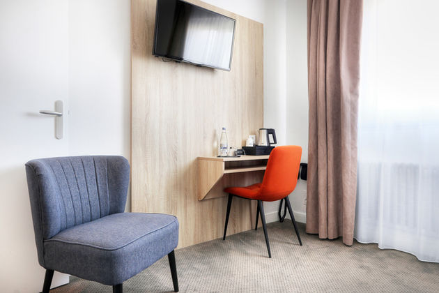 Espace bureau de la Chambre Côté Cour de l’Hôtel La Petite Sirène à Quiberon avec chaises et télévision