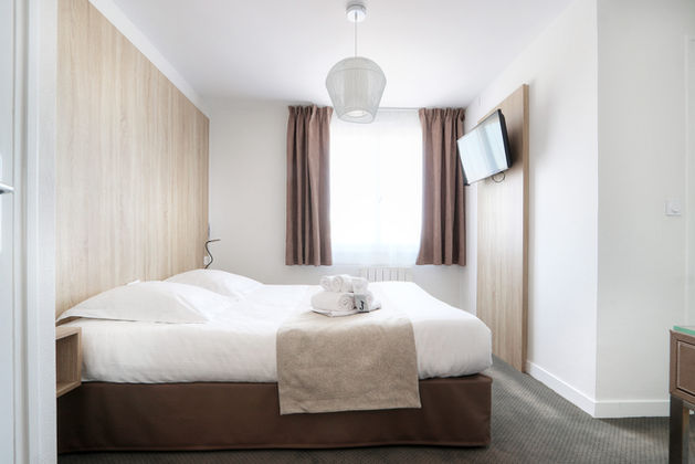 Vue intérieure de la Chambre Éco de l’Hôtel La Petite Sirène à Quiberon avec lit double et télévision