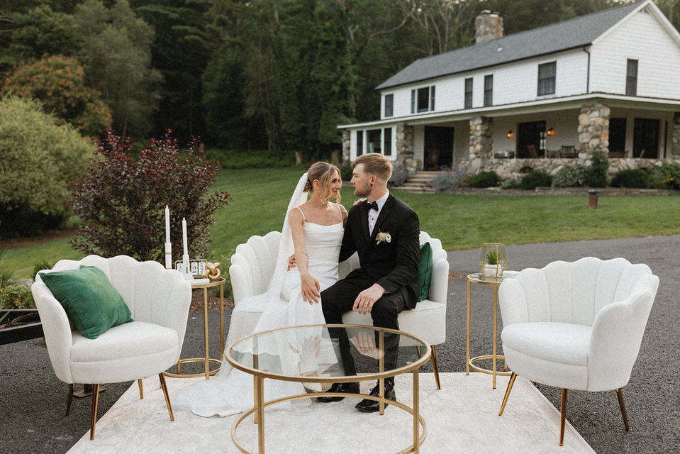Bride and groom pose on white lounge furniture at Sylvan Ridge Farm, a barn wedding venue where NJ, NY, and PA meet