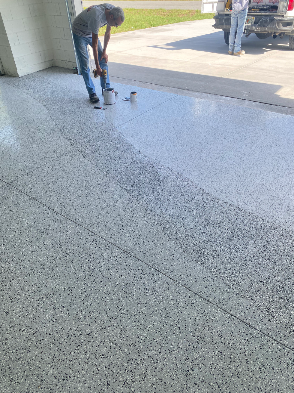Custom epoxy flake garage floor installation featuring a gray, white, and black decorative flake blend with a durable, seamless finish.