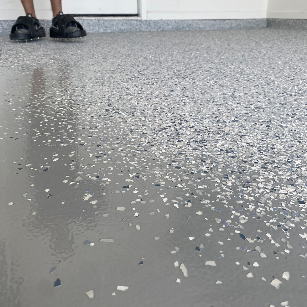 Smooth epoxy flake garage floor in a finished residential space, showcasing a clean, sealed surface with a gray-toned finish