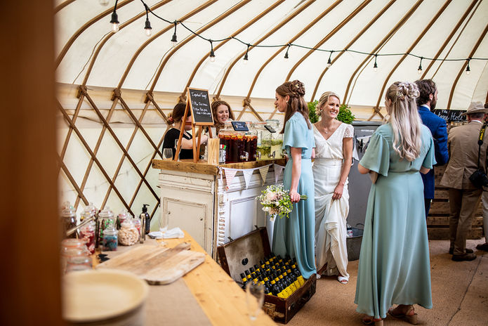 Bride and bridesmaids at bar waiting for drinks