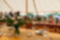 view over dressed tables ready for wedding guests in a pole marquee
