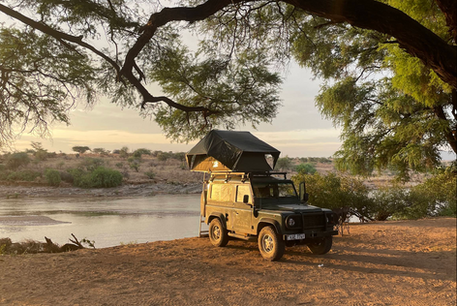 4x4 camping setup under acacia trees beside the river in Samburu National Reserve, northern Kenya