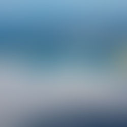 Vietnam Airlines Dreamliner jet in flight over clouds and coast. Blue and white colours, aircraft markings visible.