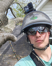 ISA Arborist Michael Shults on a roof with a tree resting on a house