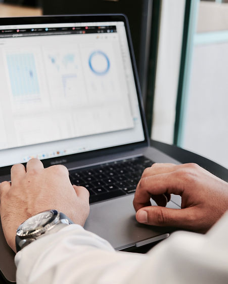 Manos de una persona sobre su computadora portátil trabajando en un archivo de análisis de datos