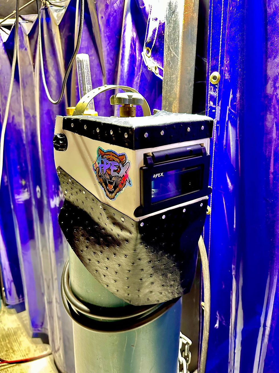 A welding hood with the APEX sticker on the side