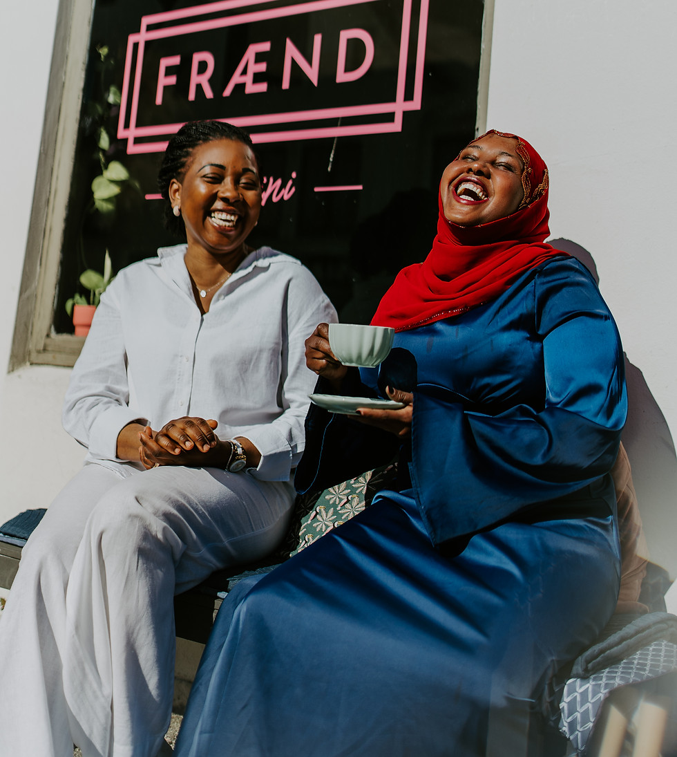 Two women smiling and drinking coffee