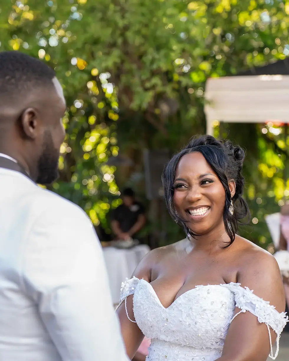 Mitchell smiles at her groom during their outdoor wedding ceremony an the Terranova Hotel in Kingston, Jamaica