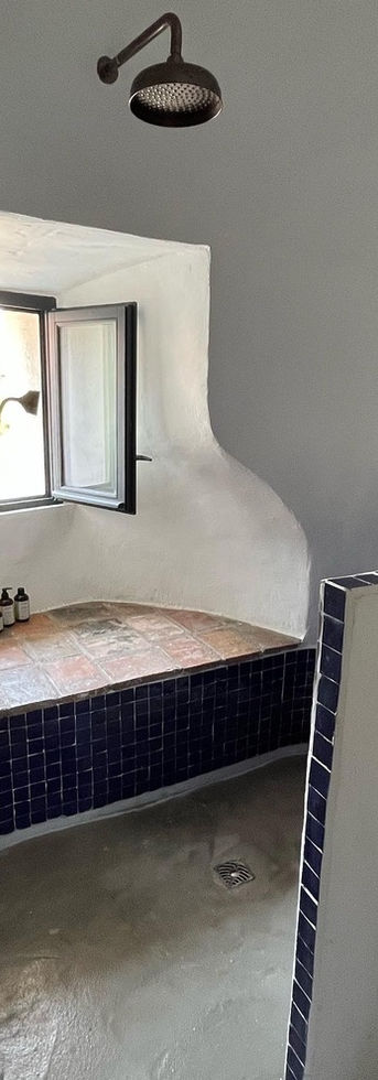 une salle d'eau ronde installée dans la tour du château, chaux blanche et bleu indigo