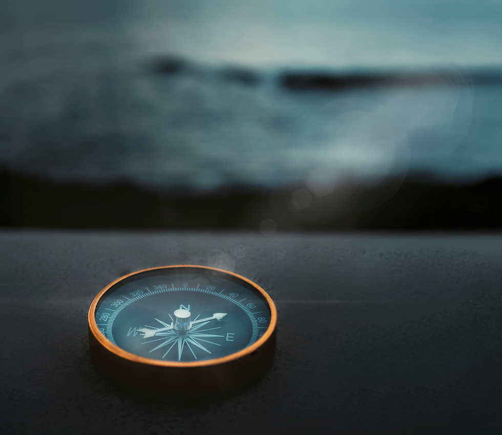 Antique compass on dark surface, ocean background