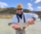 Angler holding a rainbow trout during a guided San Juan River fly fishing wade trip below Navajo Dam
