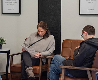 Woman and teen boy seated in a lobby area.