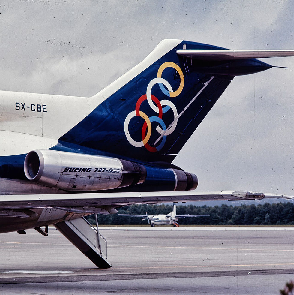 Close-up of the tail of an Olympic Airways Boeing 727-200 (SX-CBE) displaying the airline’s iconic six-ring logo.