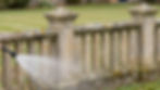 Soft wash cleaning of a stone garden fence in Haddington.