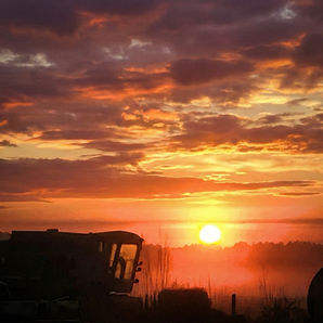 Vibrant sunset sky behind farm machinery